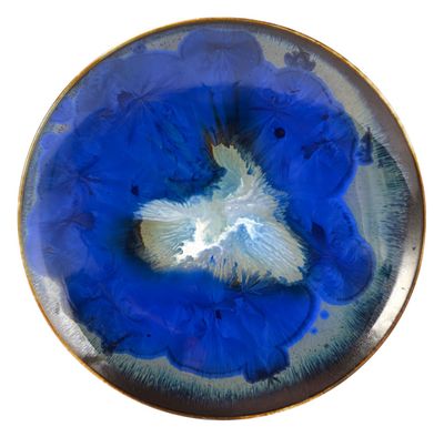 a blue plate with a white flower inside of it