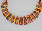 an image of a necklace made out of orange and brown beads