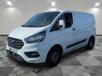 Une camionnette blanche est garée dans une grande pièce au sol carrelé.