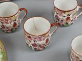 many cups and saucers sitting on a table