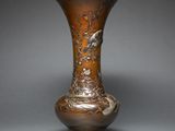 a bronze vase with birds and flowers on it