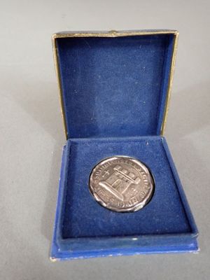 a small silver coin in a blue box on a table