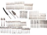 a lot of silverware on a white table