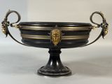 a black and gold bowl with a lion head on it