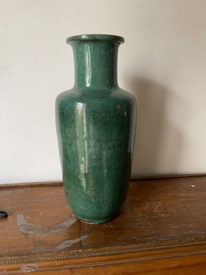 un vase vert posé sur une table en bois