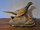 statue représentant un oiseau et un canard posés sur un rocher, posée sur une table