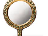 un gros plan d'un miroir sur fond blanc avec un reflet