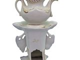 a white tea pot with a bird on top of it