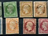 six different colored stamps of different sizes and shapes on a black surface