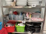 many dishes and pans on a metal shelf in a kitchen