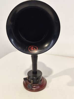un gramophone noir et rouge posé sur une table blanche