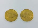 two gold coins, one of which is a eagle and the other of which is a bird