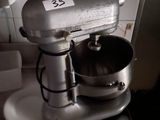 a silver mixer sitting on a counter in a kitchen
