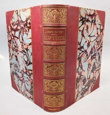 un vieux livre à la couverture rouge et à la bordure dorée
