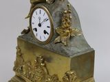 a gold clock with a statue on top of it