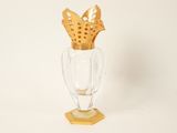 a glass vase with a gold decoration on top of it