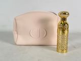 pink purse with a gold perfume bottle next to it on a white surface