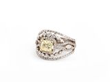 un gros plan d'une bague ornée d'un diamant jaune entouré de diamants blancs