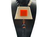 a close up of a necklace on a mannequin with a tassel