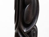 a wooden sculpture that is sitting on a white surface