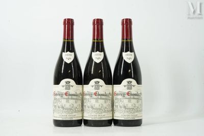 trois bouteilles de vin rouge posées sur une table blanche