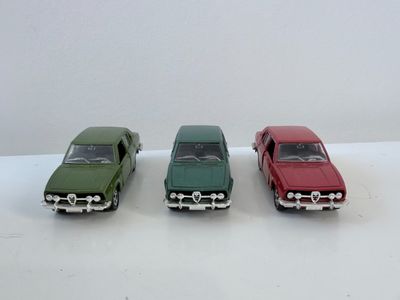 trois petites voitures posées sur une surface blanche