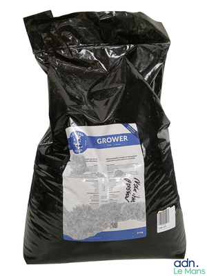 un sac noir rempli de gravier posé sur une surface blanche