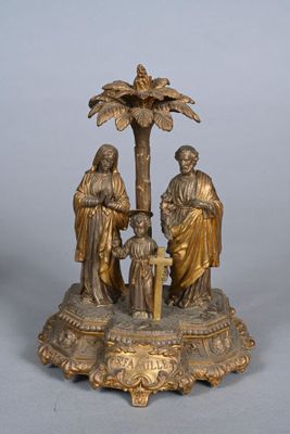 figurine en laiton représentant trois personnes et un bébé dans un palmier