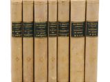 six vieux livres sont alignés sur une surface blanche