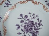 a purple and white plate with a rose design on it