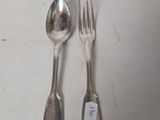 two spoons and a fork sitting on a table