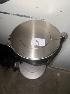 a metal pan sitting on top of a toilet in a bathroom