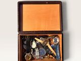 a wooden box filled with assorted items on a white surface