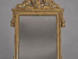 un miroir ancien avec un cadre doré et un motif représentant un oiseau