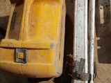 a yellow tool sitting on the ground next to other tools