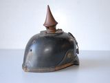 an old bell with a pointed top on a white table