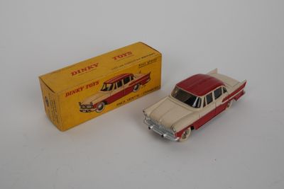 une petite voiture rouge et blanche à côté d'une boîte jaune
