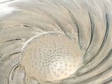 a close up of a glass bowl with a spoon inside of it