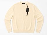 un pull blanc avec une étiquette noire dessus