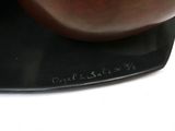 a sculpture of a man sitting on top of a black plate