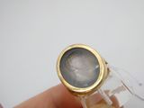 une personne tenant une bague sur laquelle figure le portrait d'un homme