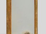 an image of a gold framed mirror sitting on top of a white wall