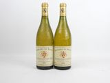 two bottles of wine sitting next to each other on a white surface