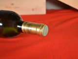 a bottle of wine sitting on a red cloth