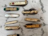 de nombreux types de couteaux de poche posés sur la table
