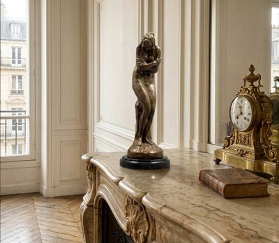 a statue of a woman standing on a table in a room