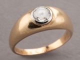 a close up of a gold ring with a white diamond