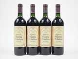 trois bouteilles de vin rouge sont alignées sur une surface blanche