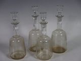 trois bouteilles en verre transparent sont alignées sur une surface blanche