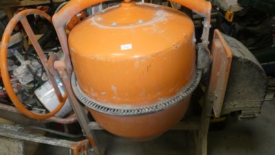 an orange tank sitting on top of a cart in a garage